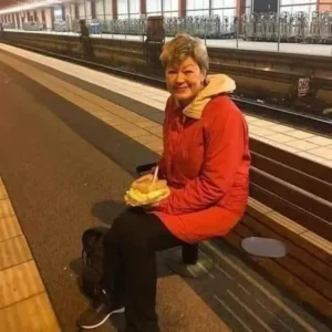 A woman is waiting for a train to return home