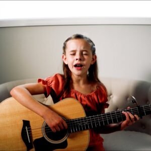 The little girl plays the guitar and sings a very beautiful song
