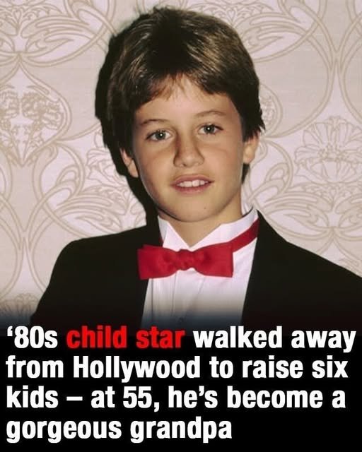 "A young actor smiling warmly, holding a child’s hand, as he walks away from a Hollywood sign in the background, symbolizing his choice to prioritize family over fame."
