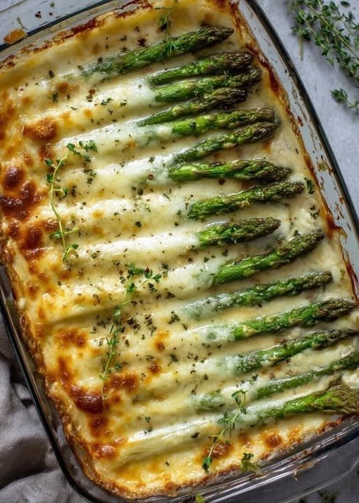 A golden-brown cheesy asparagus casserole fresh from the oven, with a crispy breadcrumb topping and melted cheese bubbling around the edges.