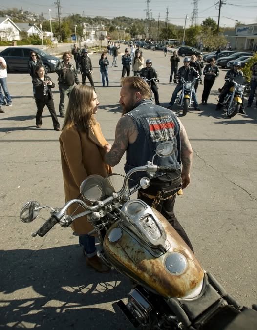 Rusty Harley-Davidson motorcycle surrounded by bikers in a Walmart parking lot during an emotional confrontation.