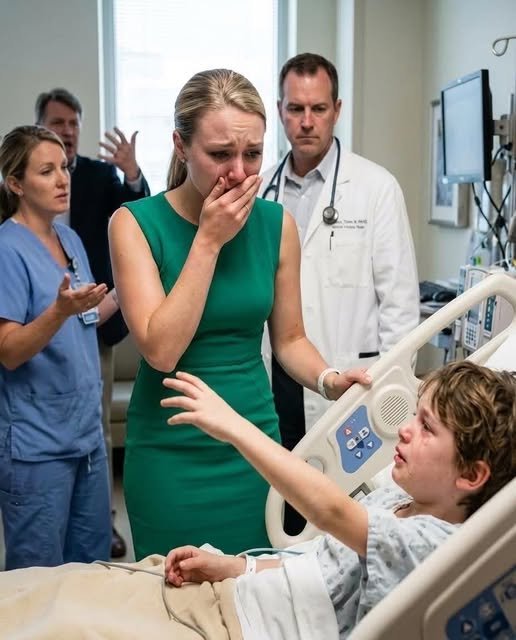 A woman stands in a hospital room doorway, her hand covering her mouth in shock as a young boy in a hospital bed looks up at her with a hopeful expression.