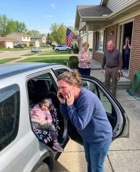 Mother holds her frightened daughter tightly outside a family home after a painful confrontation and calls for emergency help.