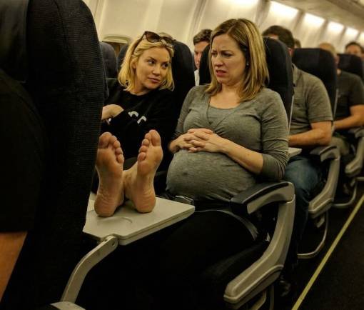 Pregnant woman on airplane seat standing up for herself during a difficult flight experience