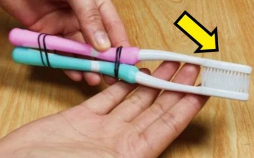 Two old toothbrushes tied together used as a cleaning tool for hard-to-reach areas