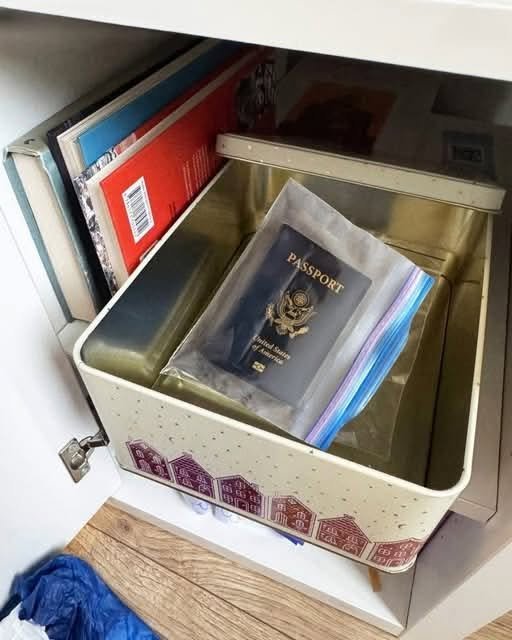"A woman holding her recovered passport, smiling triumphantly after discovering her mother-in-law hid it to ruin her vacation."
