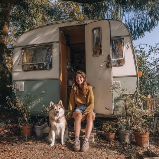 A brightly painted, retro-style caravan with colorful curtains and a cozy seating area inside, showcasing Ellie’s creative transformation.