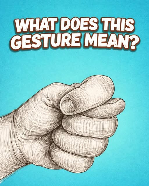 A hand making the traditional fig gesture with the thumb tucked between the fingers, a symbol with historical and cultural significance.