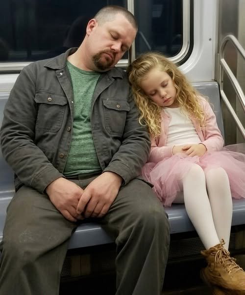 Single father hugging his daughter after her ballet recital while an emotional audience watches.