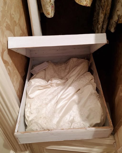 Vintage wedding dress stored in a preservation box after being discovered hidden inside a closet during a friendship betrayal.